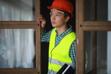 Kask ve inşaat koruyucu yelek Asyalı adam