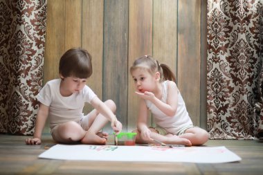 Küçük çocuklar büyük bir kağıda boya