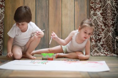 Küçük çocuklar büyük bir kağıda boya