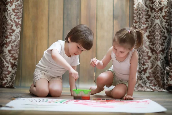 Little children paint on a large sheet of paper — Stock Photo, Image