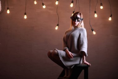 Siyah bir maske içinde sarı saçlı bir kızla