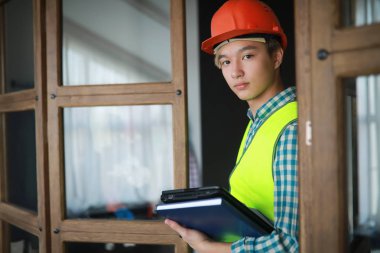 Kask ve inşaat koruyucu yelek Asyalı adam