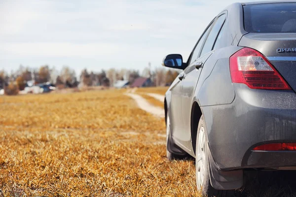 O carro está estacionado no campo de outono. O carro está a conduzir. — Fotografia de Stock