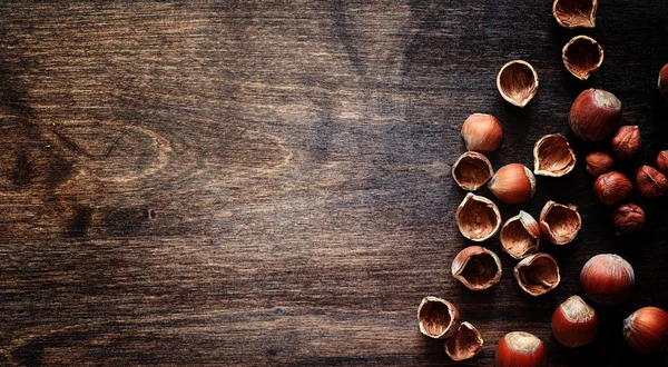 Nozes em uma mesa de madeira.Avelãs nas conchas e descascadas. Um wo — Fotografia de Stock