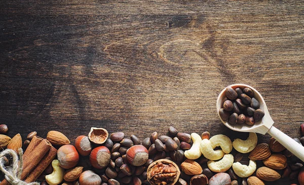 Olika nötter på ett träbord. Ceder, cashew, hasselnöt, walnu — Stockfoto