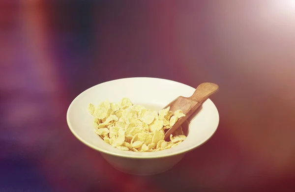 Кукурузные хлопья в тарелке. Завтрак из хлопьев с медом и миллионом — стоковое фото
