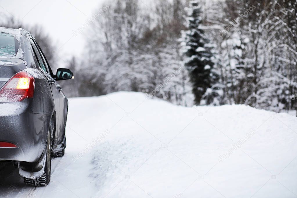 The car stands on a snow-covered road