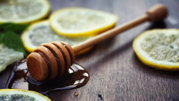 Madu dan lemon. Madu tongkat dan irisan lemon pada woo — Stok Foto