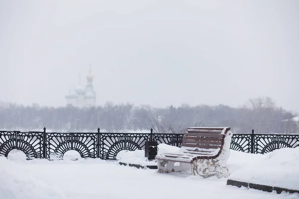Winter city landscape. Winter park covered with snow. A bench un — Stock Photo, Image