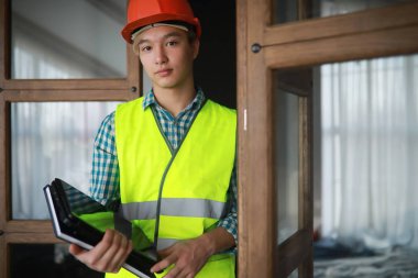 Kask ve inşaat koruyucu yelek Asyalı adam