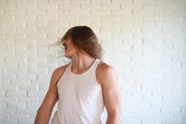 Uzun saçlı genç adam başını sallıyor.