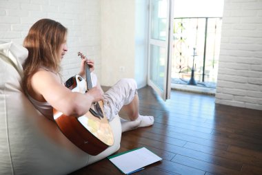 Bir gitar ile uzun saçlı Genç adam