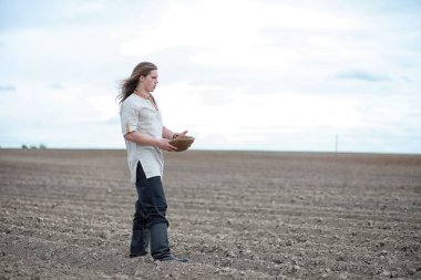 Genç bir köylü tahıl alanıyla sows