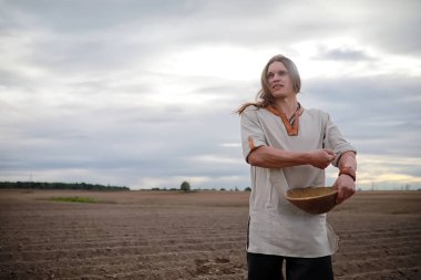 Genç bir köylü tahıl alanıyla sows