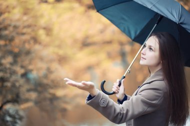 Sonbahar parkında montlu genç kız.