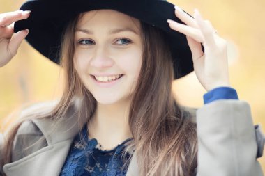 Sonbahar parkında montlu genç kız.