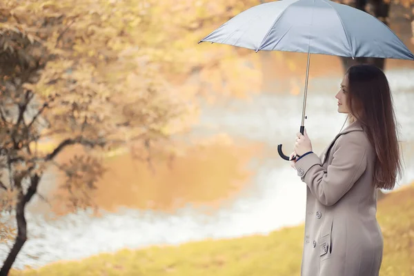 雨の中で秋の公園でコートを着た少女 — ストック写真