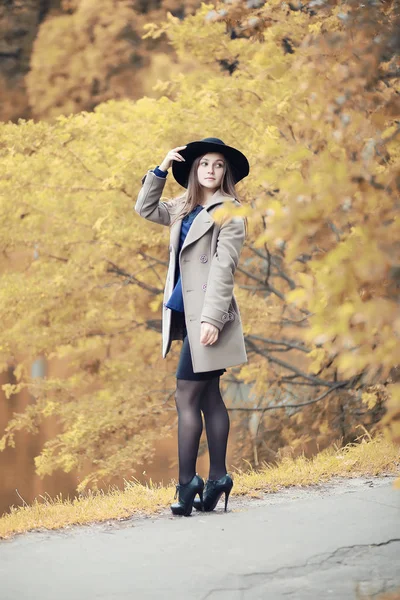 Menina jovem em um casaco no parque de outono — Fotografia de Stock