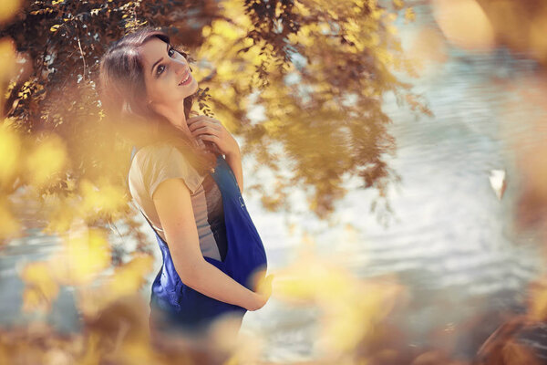 Pregnant woman on a walk in the park in autumn