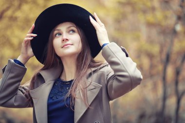 Sonbahar parkında montlu genç kız.