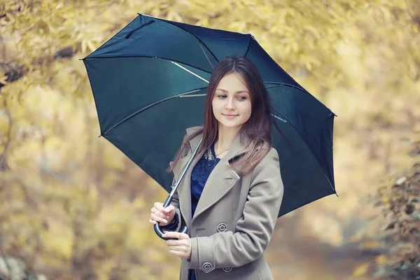 Giovane ragazza in un cappotto nel parco autunnale — Foto Stock