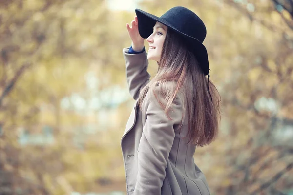 Giovane ragazza in un cappotto nel parco autunnale — Foto Stock