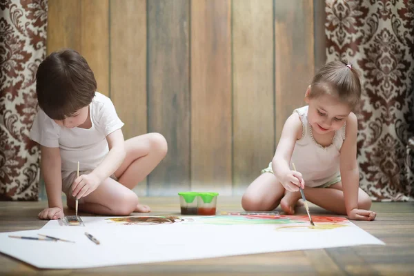Маленькие дети рисуют на большом листе бумаги — стоковое фото