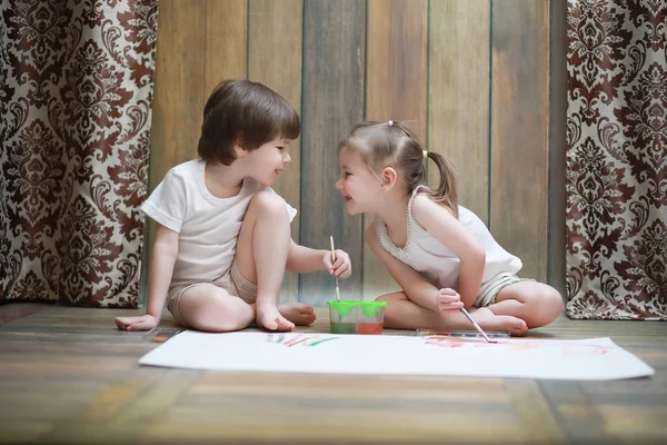 Malé děti malovat na velký list papíru — Stock fotografie