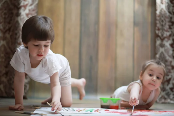 Petits enfants peignent sur une grande feuille de papier — Photo