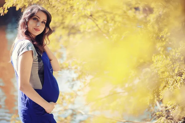 Mujer embarazada en un paseo por el parque — Foto de Stock