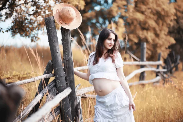 Mujer embarazada en la naturaleza para un paseo en el otoño — Foto de Stock