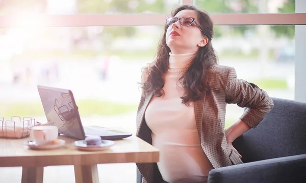 Mujer embarazada trabajando en la computadora en la cafetería — Foto de Stock