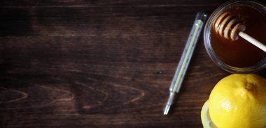 Uyuşturucu ve hap ahşap bir masa üzerinde. Soğuk algınlığı önlemek için çeşitli demektir. Çay limon ve bal ile. Cam bardak çay dilim limon ve bir kavanoz bal ile.