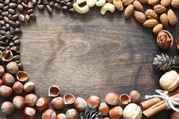 Olika nötter på ett träbord. Ceder, cashew, hasselnöt, walnu — Stockfoto