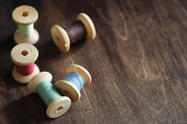 Filo da cucire su uno sfondo di legno. Set di fili su bobine — Foto Stock