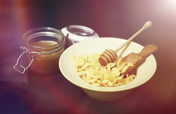 Кукурузные хлопья в тарелке. Завтрак из хлопьев с медом и миллионом — стоковое фото
