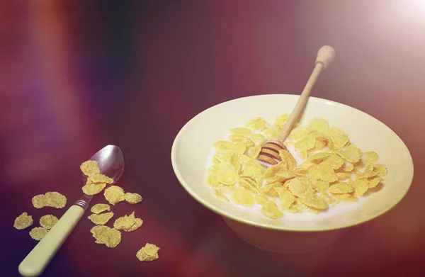 Corn flakes in a plate. Breakfast from flakes with honey and mil