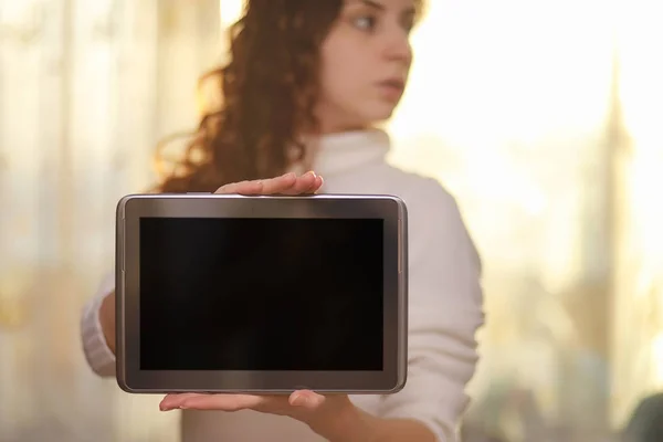 The girl is holding a tablet. The girl has a computer with a scr — Stock Photo, Image