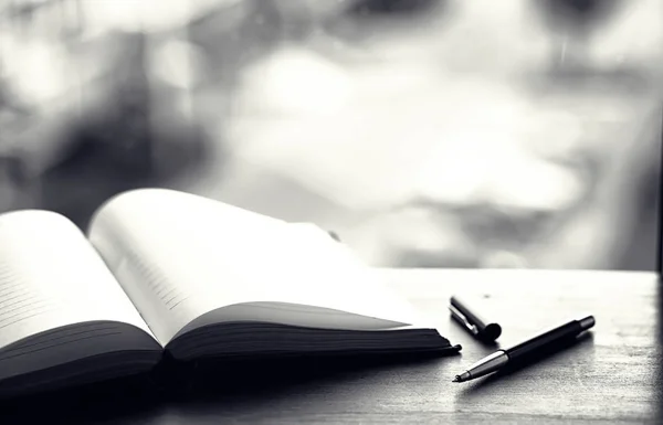 Livre ouvert et une table noir et blanc — Photo