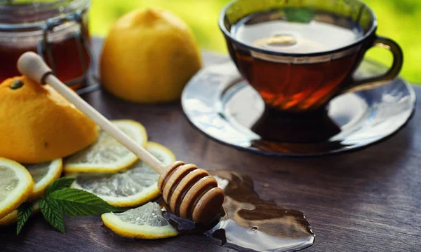Tee mit Zitrone und Minze in der Natur. eine Tasse heißen Minztee mit le — Stockfoto