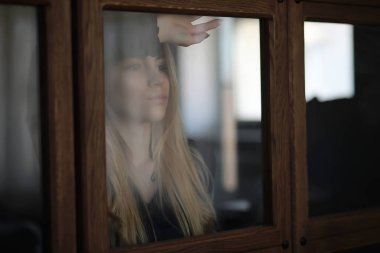 Genç bir kız büyük bir dairede dinleniyor.