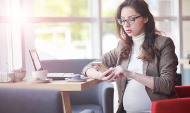 Kafede bilgisayarda çalışan hamile kadın