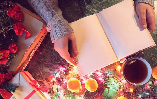 Man with a blank book in his hands for the New Years table with — Stock Photo, Image