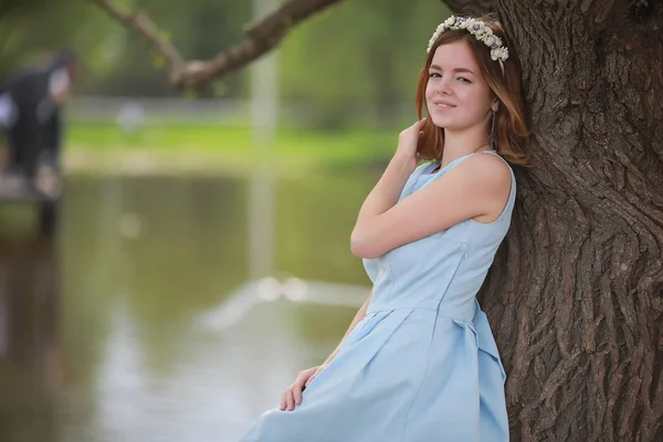 Flicka i blå klänning i grön park — Stockfoto