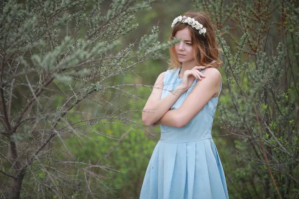 Dívka v modrých šatech v zeleném parku — Stock fotografie
