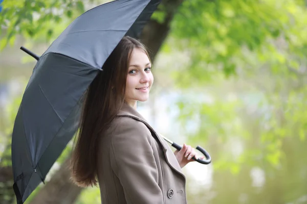 Young girl in a coat in a spring park — Stock Photo, Image