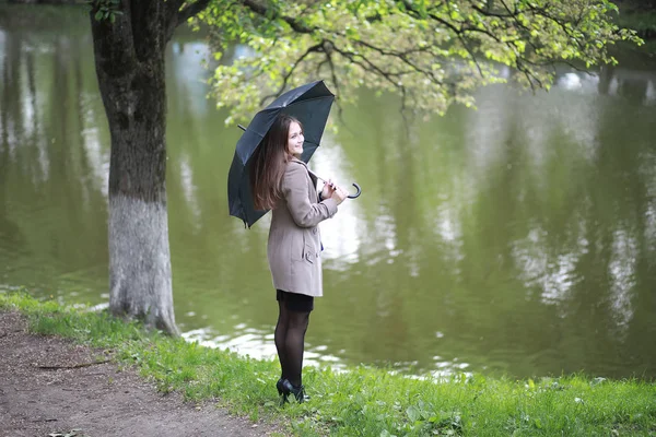 Jeune fille dans un manteau dans un parc de printemps — Photo