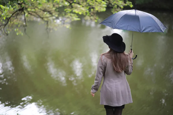 Ung flicka i en päls i en spring park — Stockfoto