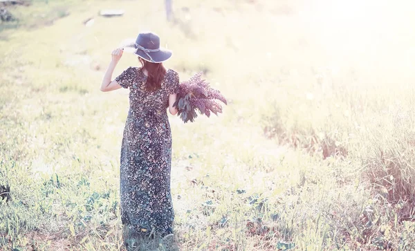 Chica embarazada en un campo con flores — Foto de Stock