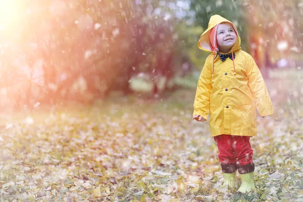 Un niño en un impermeable para un paseo fuera en otoño —  Fotos de Stock